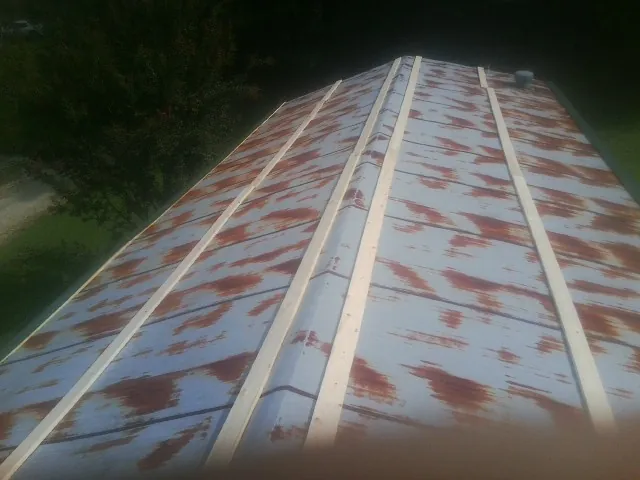 Rusted metal roof panels with new wood purlins before replacement — Storm Damage Roof Repair in Margaretville by Roofing Brothers