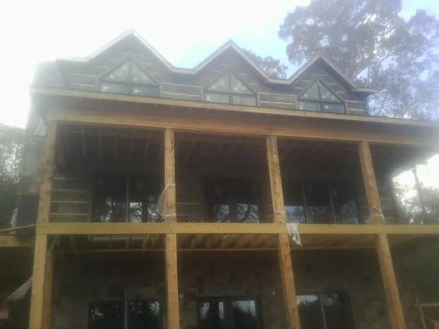 Dormers and porch framing on a large log home under construction — Roof Coating work by our crew in Margaretville