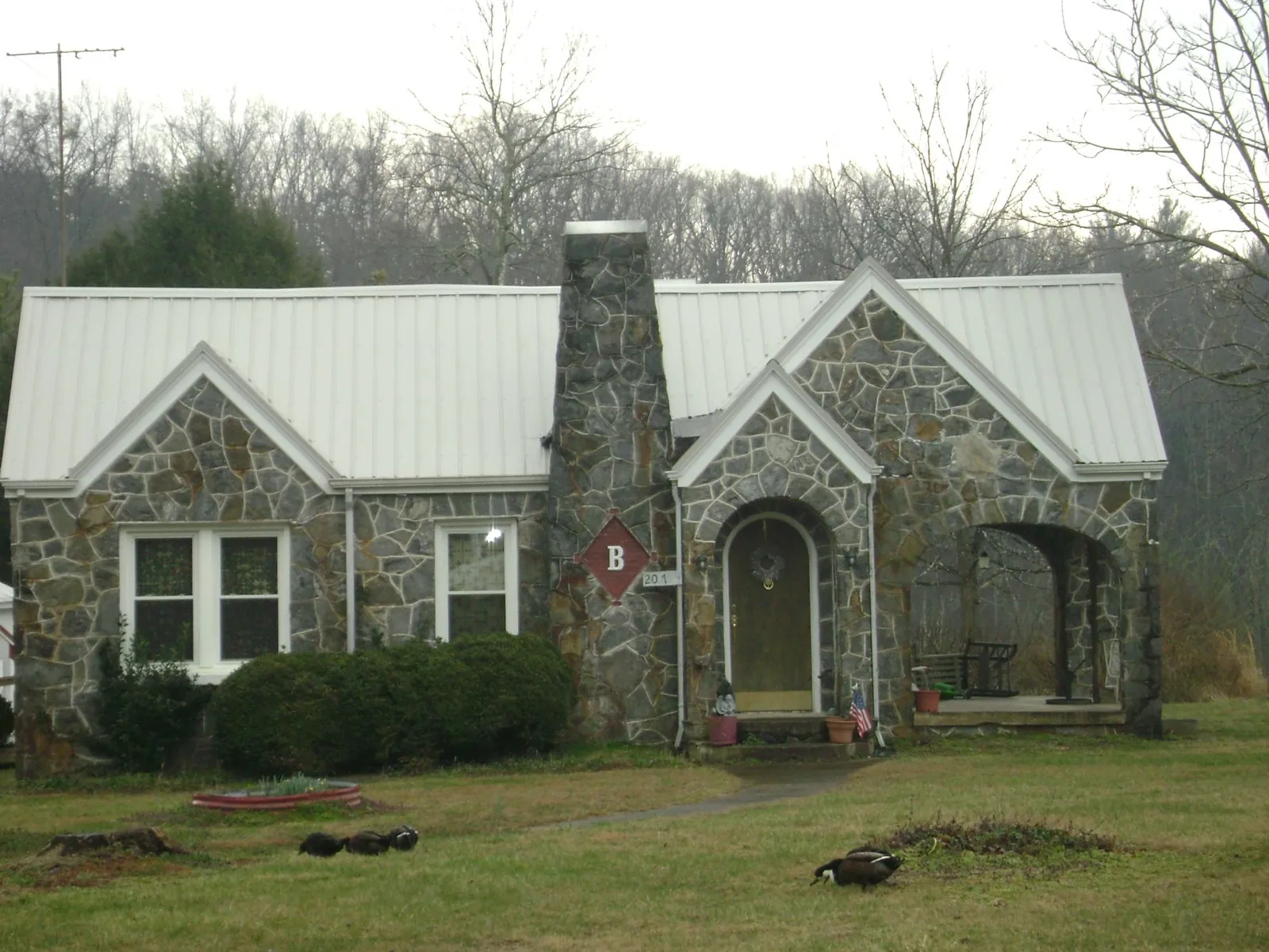 White metal roof on a stone cottage with steep gables in Margaretville
