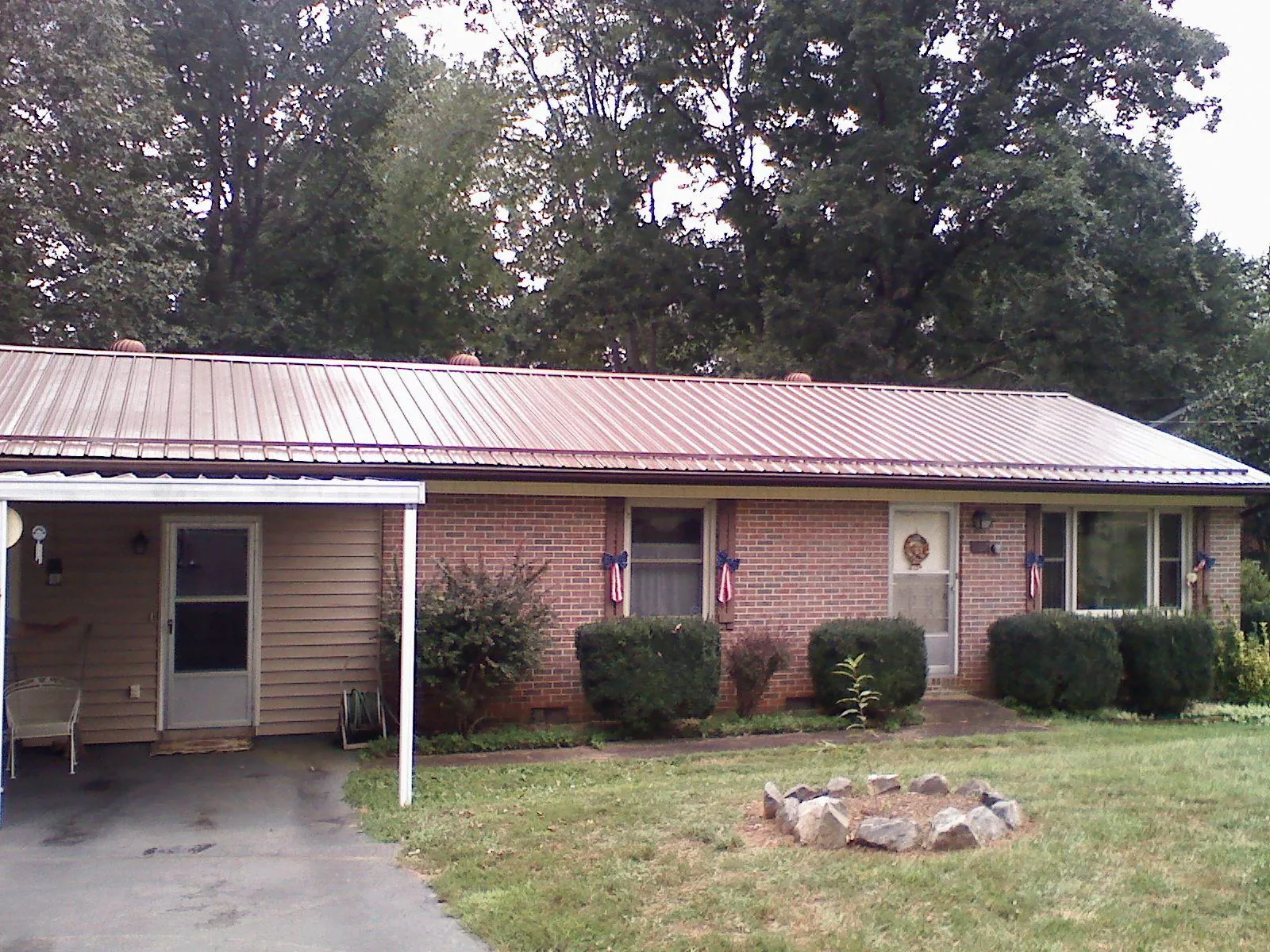 Bronze metal roof and carport on a brick ranch home — Roof Repair work by our crew in Margaretville